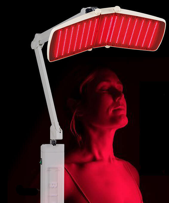 Woman sitting under Bio Light 7000sc in Red mode.