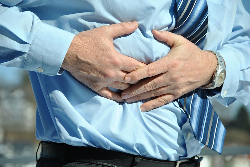 Torso of man. Man is grasping at side of body in pain.