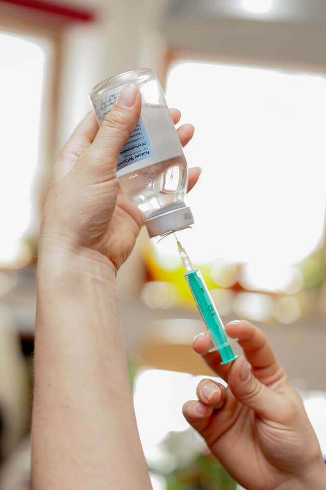 hands drawing vaccination into a syringe