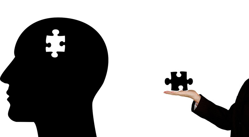 illustration of human head with puzzle piece missing with a hand coming out of the side with the missing puzzle piece in it, reaching for the head