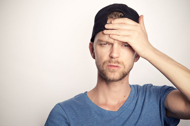 Man holding his head as if having a headache