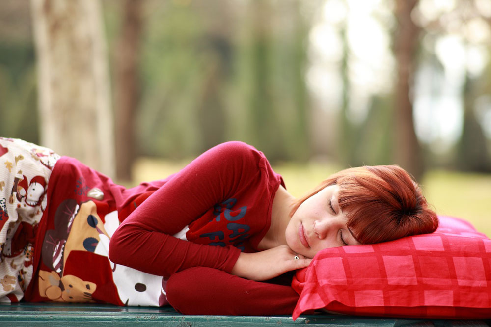 woman sleeping on her side outdoors